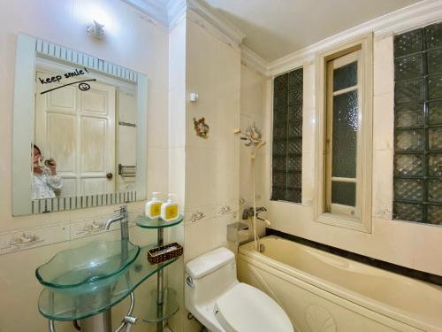a bathroom with a sink and a tub and a toilet at Lava Homestay Hải Phòng in Hai Phong