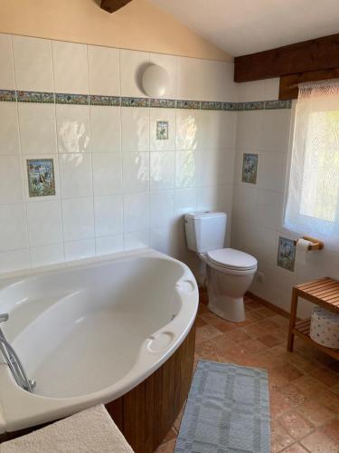 une salle de bain avec une baignoire blanche et des toilettes dans l'établissement Maison familiale 6 personnes, à La Faute-sur-Mer