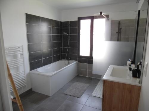 une salle de bain avec une baignoire et un lavabo dans l'établissement Villa Jules Verne, au Crotoy