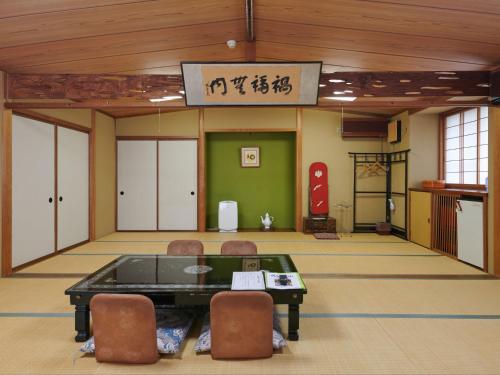 a room with a table and chairs in a building at Tabist Ryokufuen Kiyoharu in Takayama