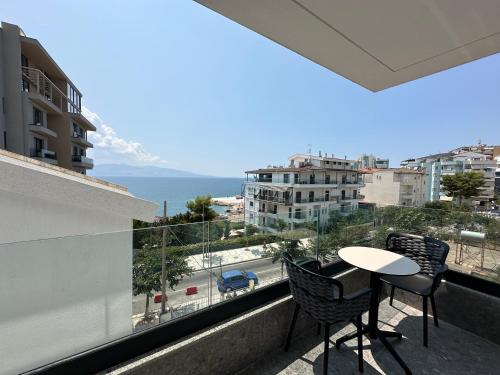 a balcony with a table and chairs and the ocean at DREAM HOTEL SARANDA in Sarandë