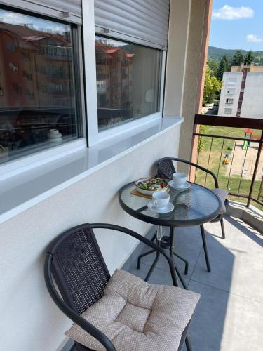 a small table and chairs on a balcony with a table andasteryasteryasteryastery at Apartman Lana in Teslić