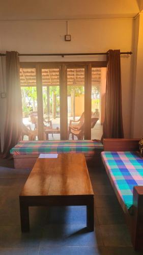 a living room with two beds and a table at BonaVista Beach Hotel in Arugam Bay