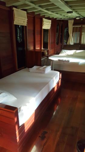 a group of beds sitting in a room at Ruean Mai Chai Khlong in Amphawa