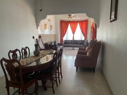 a living room with a table and chairs and a couch at NZ Homestay in Melaka