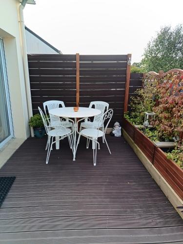 a patio with a table and chairs on a deck at Petit appartement à la campagne proche mer in Missillac