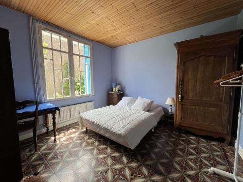 une chambre avec un lit et une grande fenêtre dans l'établissement Maison typique 30 s proche plage, à Saint-Gilles-Croix-de-Vie