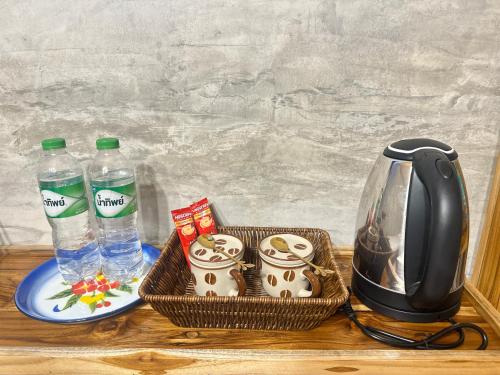 a table with a tea kettle and two cups and water at Fatima homestay ฟาติมาโฮมสเตย์ in Ban Nam Lat