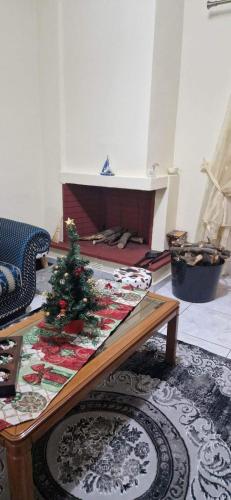 a living room with a christmas tree on a coffee table at Angela's Apartment with beautiful balcony view in Agios Konstantinos Fthiotida