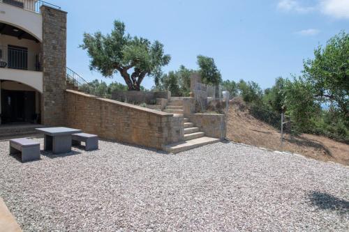 a patio with a bench and stairs next to a building at Modone Villas in Peloponnese in Methoni
