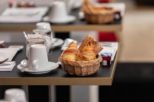 a basket of croissants sitting on a table at Hôtel Churchill Bordeaux Centre in Bordeaux