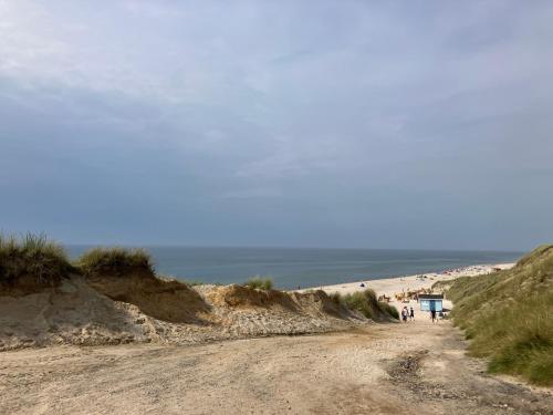 a dirt road leading to a beach with people on it at Nordpalais vor Sylt in Emmelsbüll-Horsbüll