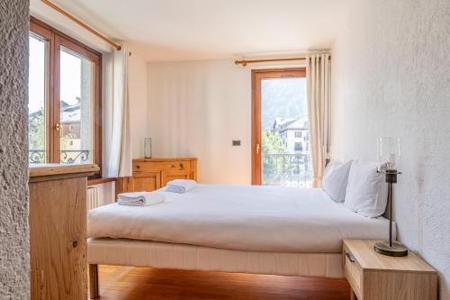 une chambre avec un grand lit et une fenêtre dans l'établissement Coeur des Alpes - A spacious 3-bedroom apartment with spectacular views, à Chamonix-Mont-Blanc