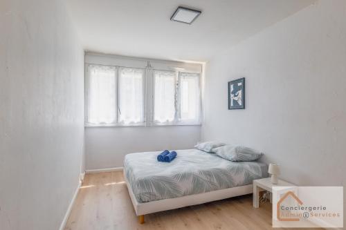 une chambre blanche avec un lit et une fenêtre dans l'établissement La Belle Escale - 2 à 6 voyageurs, à Saint-Priest