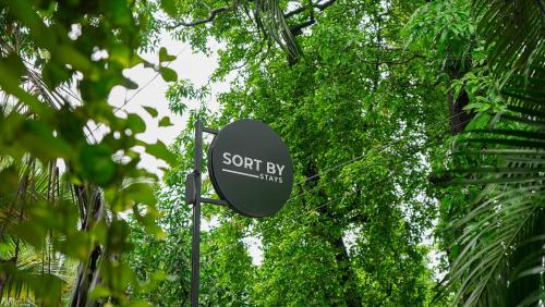 a sign that says sport by wings in front of trees at Sortby Stays, Vagator in Vagator