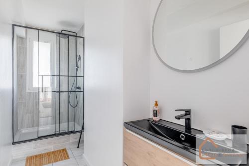 une salle de bain avec un lavabo et un miroir dans l'établissement La Belle Escale - 2 à 6 voyageurs, à Saint-Priest