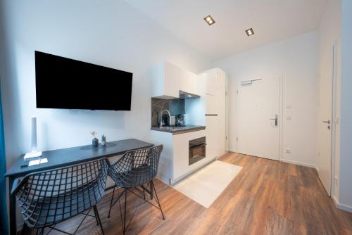 a living room with a desk and a tv on the wall at Nurban Apartments City 2 in Nürnberg