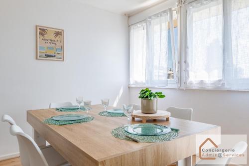 - une salle à manger avec une table en bois et des assiettes dans l'établissement La Belle Escale - 2 à 6 voyageurs, à Saint-Priest