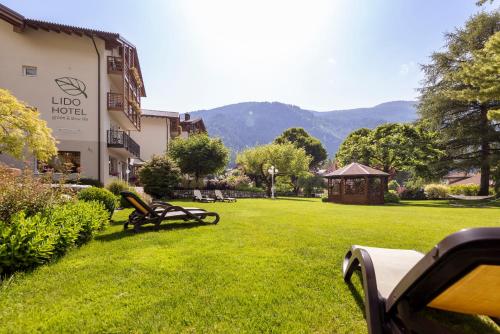 a park with benches and a gazebo in the grass at Hotel Lido - slow & natural living in Molveno