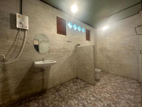 a bathroom with a sink and a mirror and a toilet at Fatima homestay ฟาติมาโฮมสเตย์ in Ban Nam Lat