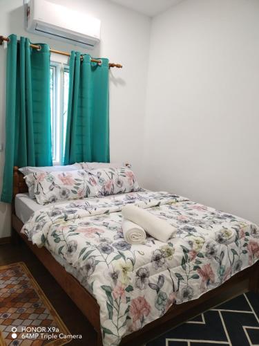 a bed in a room with green curtains at Z&S Gerik Hillview Homestay in Gerik