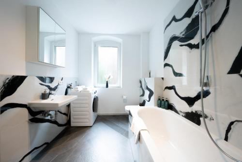 a bathroom with a tub and a sink at Nurban Apartments City 2 in Nürnberg