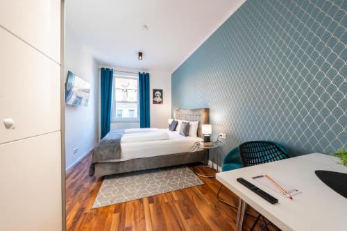 a bedroom with a bed and a desk in a room at Nurban Apartments City 2 in Nürnberg