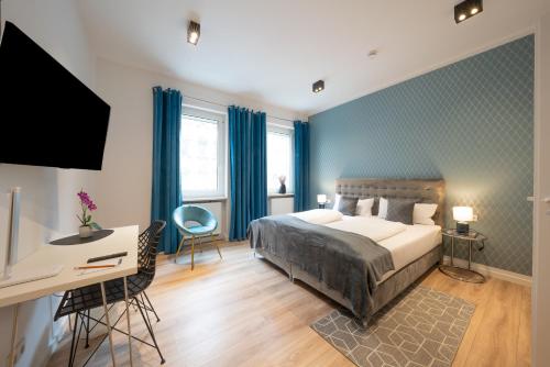 a bedroom with a bed and a desk and a television at Nurban Apartments City 2 in Nürnberg