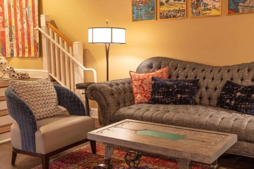 a living room with a couch and a chair at The Kendall Hotel at the Engine 7 Firehouse in Cambridge