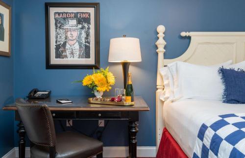 a bedroom with a bed and a desk with a lamp at The Kendall Hotel at the Engine 7 Firehouse in Cambridge