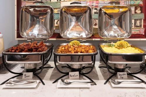 a buffet of different types of food on trays at The Kendall Hotel at the Engine 7 Firehouse in Cambridge
