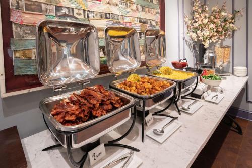 a buffet with four trays of food on a counter at The Kendall Hotel at the Engine 7 Firehouse in Cambridge