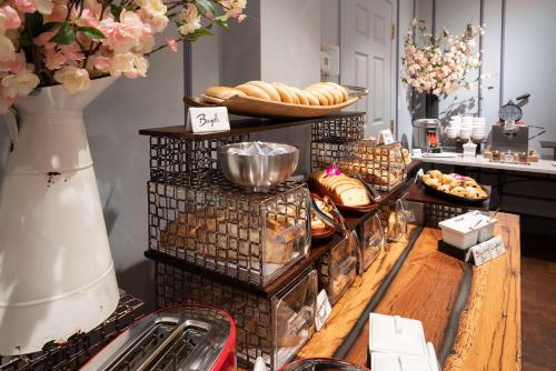a buffet with bread and pastries on a table at The Kendall Hotel at the Engine 7 Firehouse in Cambridge