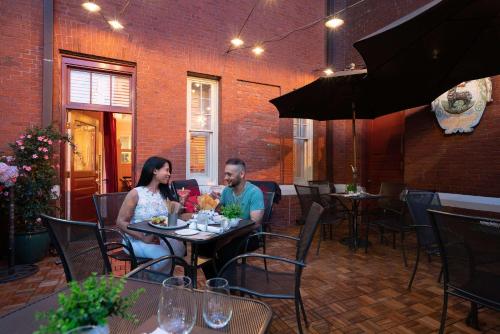 a man and woman sitting at a table in a restaurant at The Kendall Hotel at the Engine 7 Firehouse in Cambridge
