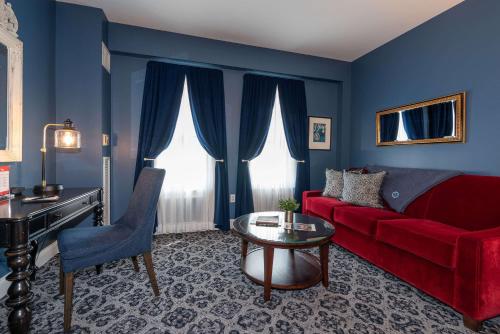 a living room with a red couch and a table at The Kendall Hotel at the Engine 7 Firehouse in Cambridge