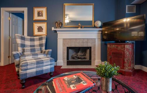 a living room with a fireplace and a tv at The Kendall Hotel at the Engine 7 Firehouse in Cambridge