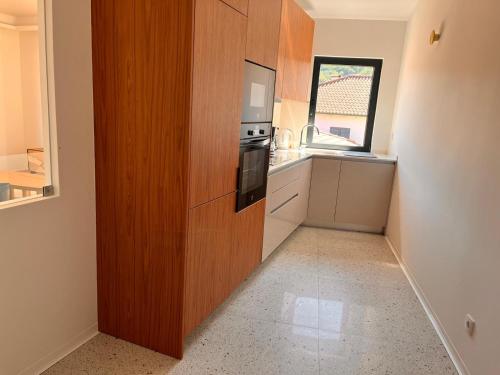 a small kitchen with a wooden wall with a stove at Casa Sao Bento in Arcos de Valdevez