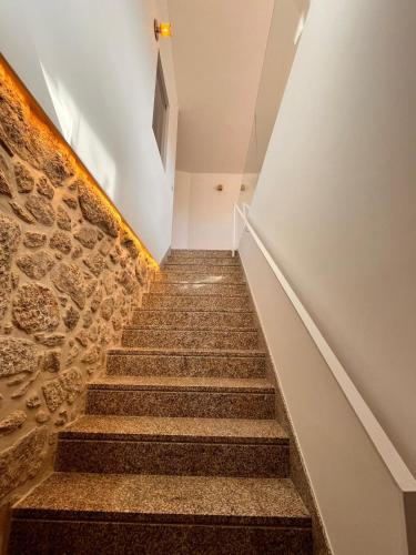 a staircase in a building with a stone wall at Casa Sao Bento in Arcos de Valdevez