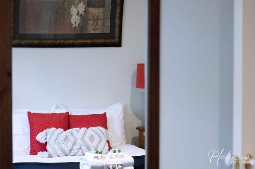 a bedroom with a bed with red and white pillows at Magnolia By Lake in Wendouree