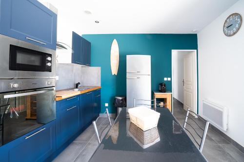 a kitchen with blue cabinets and a blue wall at Casa Jade - Appt pour 4 in Fitou
