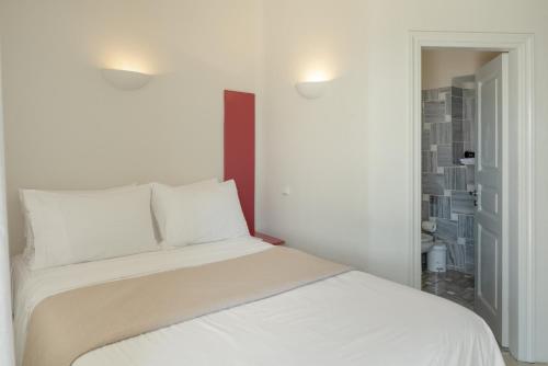 a white bed with white pillows in a bedroom at Villa Coventina in Agios Ioannis Mykonos
