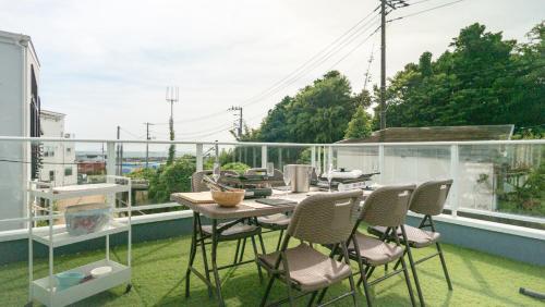 a patio with a table and chairs on a balcony at Beachside base KURUWA in Yokosuka