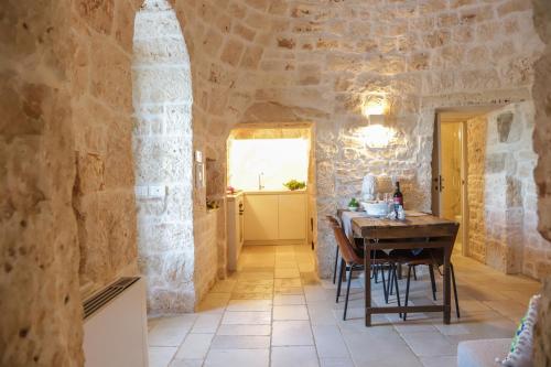 a dining room with a table in a stone building at TD Trulli Balice Cozy Trulli with Pool in Antonelli