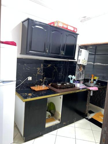 a kitchen with black cabinets and a counter top at Martil Bel appartement lumineux, situé à seulement proche de la plage, idéal pour les vacances en famille ou entre amis, proche commerces in Martil