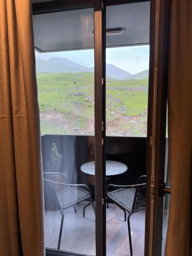 a view of a table and chairs through a window at New Gudauri Apartment NEO 223 in Gudauri
