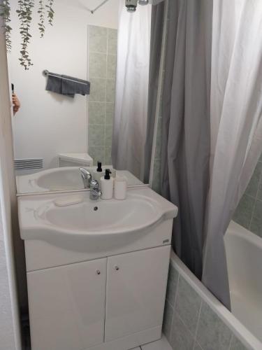 une salle de bain blanche avec un lavabo et une douche dans l'établissement Maison 3 pièces 6 personnes, à Saint-Saturnin-lès-Avignon