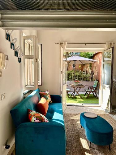a living room with a blue couch and a table at La Casetta del Centro Luminoso loft con terrazzo e giardino in Biella