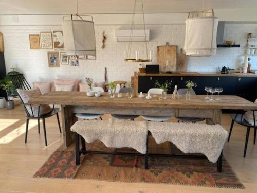 a large wooden table in a living room with chairs at Atriumshus for leie under ONS 2024 in Stavanger