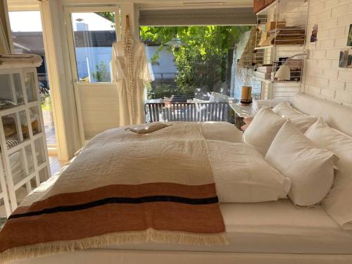 a large white bed in a room with a window at Atriumshus for leie under ONS 2024 in Stavanger