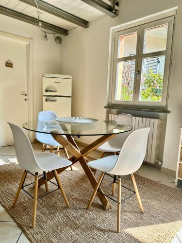 a dining room with a glass table and chairs at La Casetta del Centro Luminoso loft con terrazzo e giardino in Biella
